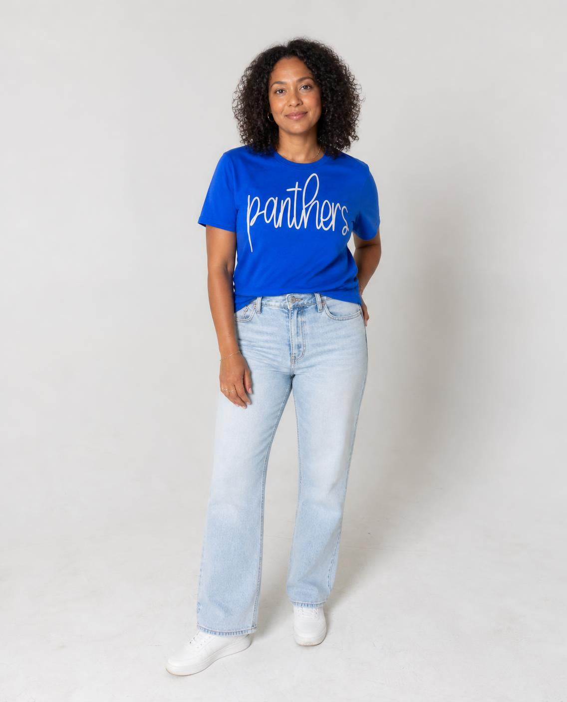 Woman wearing the royal blue cursive panthers tee with light-wash jeans