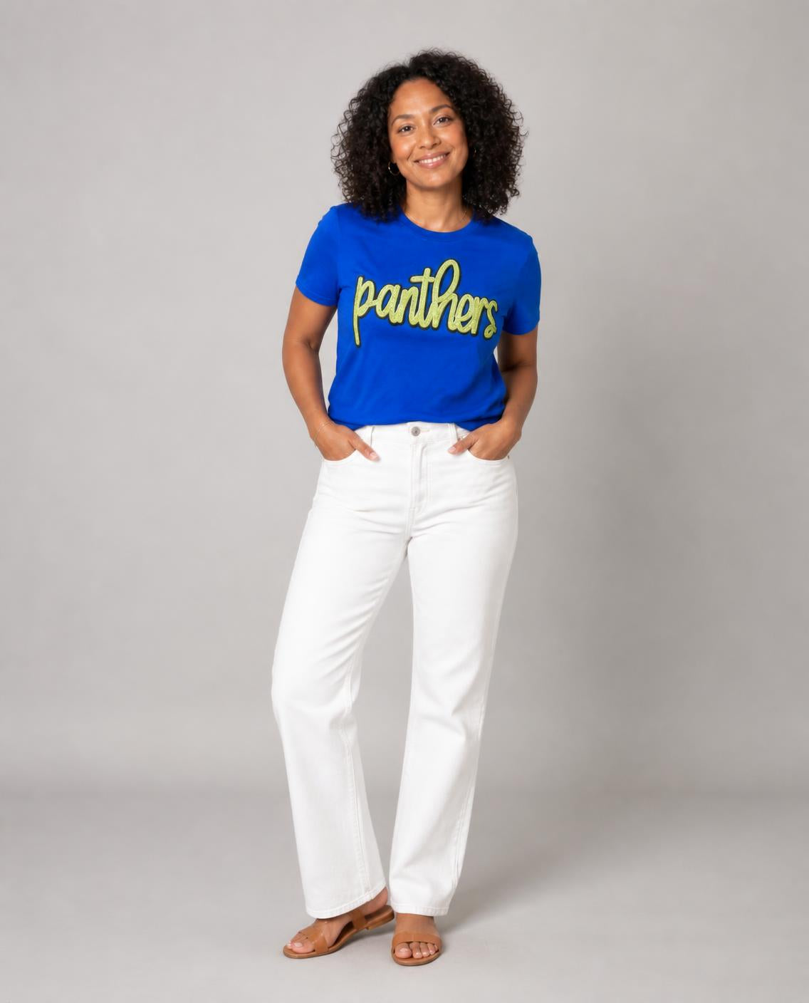 Woman wearing the royal blue sequin panthers tee with white jeans