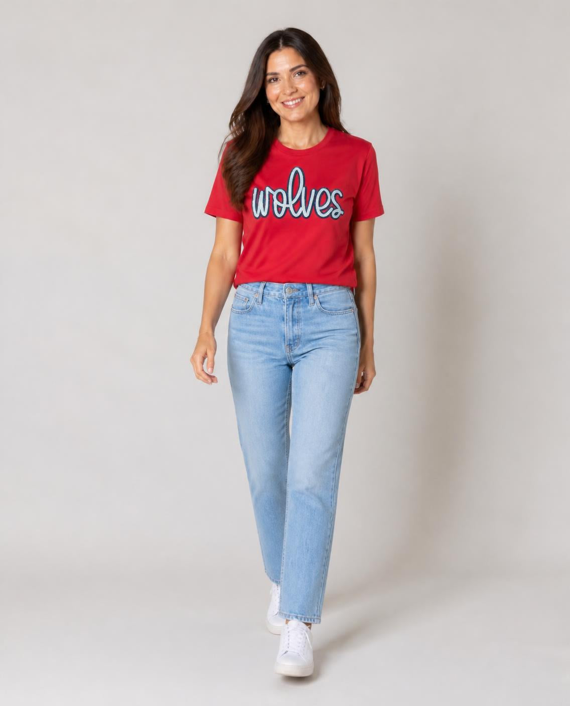 Woman wearing the scarlet sequin wolves tee with light-wash jeans